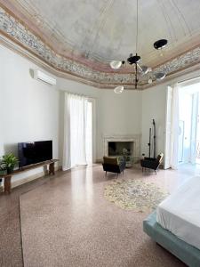 a large white room with a bed and a fireplace at Roiss Haus Suites in Lecce