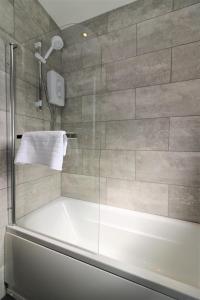 a bath tub in a bathroom with a shower at Signature - Carfin House in Carfin