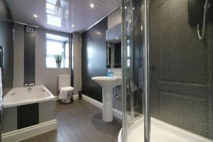 a bathroom with a tub and a sink and a shower at Signature - Kirkhill Lower in Kirkmuirhill