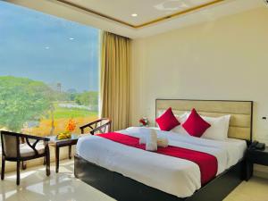sypialnia z dużym łóżkiem i dużym oknem w obiekcie Stay @Northview park hotel zirakpur w mieście Zirakpur