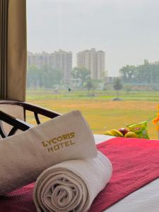 a towel on a bed with a view of a field at Stay @Northview park hotel zirakpur in Zirakpur