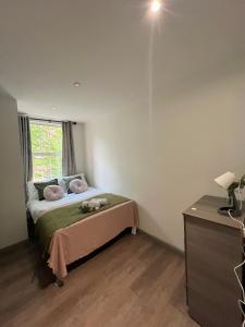 una camera da letto con un letto con cuscini rosa e una finestra di 3 Bedroom Flat in King’s Cross, St Pancras’s. 2 minutes to Euston. a Londra