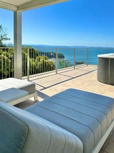 a bed on a balcony with a view of the ocean at Maximilian Suites in Trieste