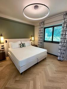 a bedroom with a large white bed and a large window at Maximilian Suites in Trieste