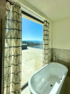 a bath tub in a bathroom with a large window at Maximilian Suites in Trieste