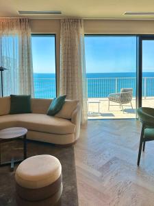 a living room with a couch and a view of the ocean at Maximilian Suites in Trieste