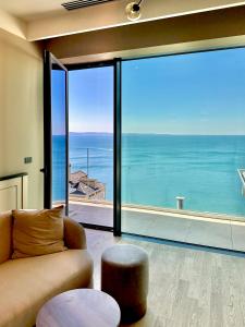 a living room with a couch and a view of the ocean at Maximilian Suites in Trieste