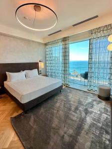a bedroom with a large bed and a large window at Maximilian Suites in Trieste