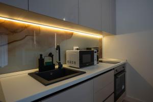 a kitchen counter with a sink and a microwave at Love Luxury studio in Predeal