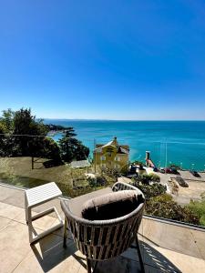 a balcony with a chair and a table and the ocean at Maximilian Suites in Trieste