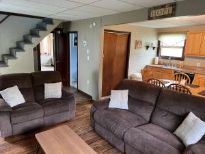 a living room with two couches and a kitchen at Echo Valley Cottages in Coolbaugh