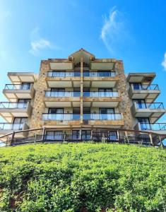 a tall building with a hill in front of it at Capitanias Hotel in Águas de Lindóia