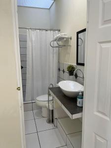 a white bathroom with a sink and a toilet at Chalchuapa, Santa Ana La Casa de Sussy, El Salvador in Chalchuapa