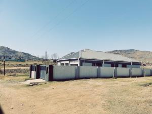 a fence in front of a building with a house at Stunning Modern Home in Maseru in Maseru