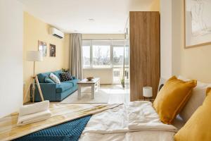 a bedroom with a bed and a blue couch at Central located 1BDR peaceful apt Fast Wi-fi in Sofia