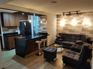 uma sala de estar com um sofá e uma cozinha com um bar em Apartamento cerca al aeropuerto em Rionegro