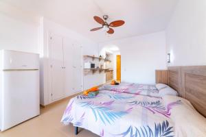 a bedroom with two beds and a refrigerator at Estudio en la playa in Roquetas de Mar +13 photos