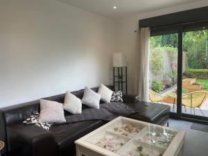 a black leather couch in a living room at Paisible Duplexe sur Villeneuve d ascq in Annappes