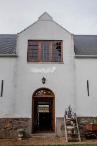 a white building with a door and a window at Heins Manor House in Stellenbosch
