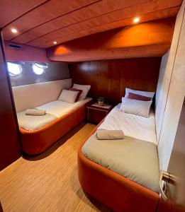 Nuit insolite à bord d'un Yacht في مارسيليا: سريرين في غرفة صغيرة على متن قارب