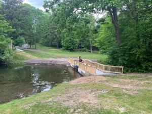 eine Person, die auf einer Brücke über einen Fluss steht in der Unterkunft Echo Valley Cottages in Coolbaugh