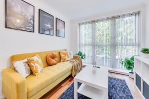 un soggiorno con divano giallo e tavolo di Cosy 1 Bed Apartment - Canary Wharf, Limehouse a Londra
