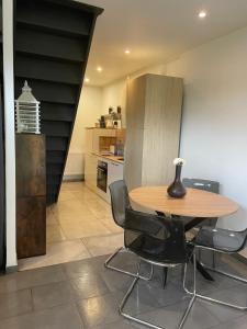 uma cozinha com uma mesa de madeira e cadeiras pretas em Paisible Duplexe sur Villeneuve d ascq em Annappes