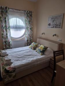 a small bedroom with a bed with a window at Hotel Mikorzyn in Ślesin