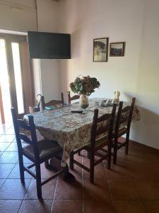 a dining room table with chairs and a vase on it at Mini House Tagliacozzo in Tagliacozzo