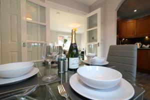 a dining table with a bottle of wine and glasses at Signature - Chapelhall House in Chapelhall