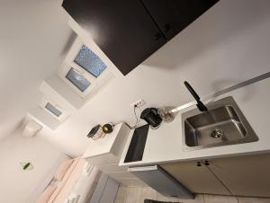 a kitchen with a stainless steel sink and windows at Petite Studio With Ensuite Bathroom in Zagreb