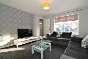 un soggiorno con divano e TV di Signature - Chapelhall House a Chapelhall