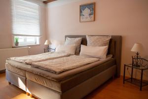 1 dormitorio con 1 cama con sábanas y almohadas blancas en Café Burgstraße en Wernigerode