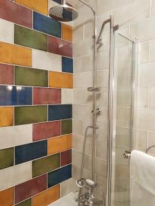 a bathroom with a shower with a colorful tile wall at East Central London -Studio in London