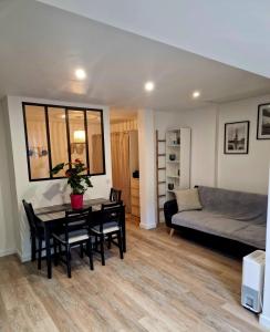 una sala de estar con una mesa y un sofá en Charment studio proche Paris 15, en Malakoff