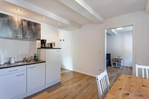 a kitchen with white cabinets and a wooden table at alter Speicher in Warendorf