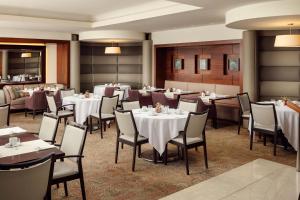 une salle à manger avec des tables et des chaises blanches dans l'établissement Sheraton Bratislava Hotel, à Bratislava