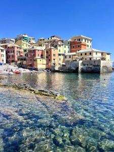 um grupo de edifícios na costa de uma massa de água em La Perla di Boccadasse em Gênova