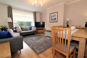 a living room with a table and a dining room at Signature - Gordon House in Glasgow