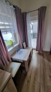 a living room with a table and a window at Hotel Mikorzyn in Ślesin