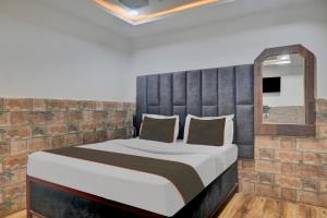 a bedroom with a large bed with a brick wall at Collection O New Hotel River Side in Bilāspur