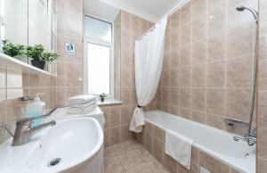 y baño con lavamanos, bañera y lavamanos. en Mini-Hotel Guest Residence en Kiev