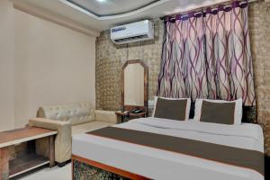 a bedroom with a large bed and a couch at Collection O New Hotel River Side in Bilāspur