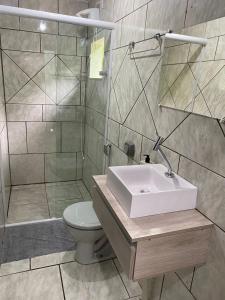 a bathroom with a sink and a shower and a toilet at Suites da Rota - Pomerode SC in Pomerode