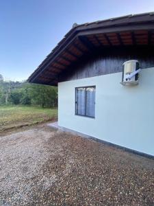 a white building with a window on the side of it at Suites da Rota - Pomerode SC in Pomerode