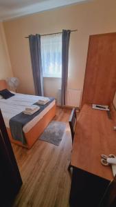 a bedroom with a bed and a desk and a window at Hotel Mikorzyn in Ślesin