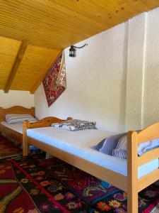 two beds in a room with a wooden ceiling at Etno-house Lukomir in Lukomir