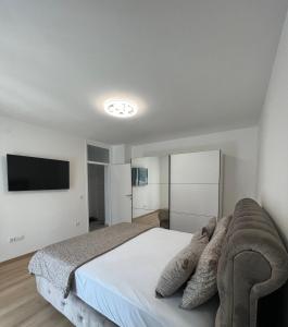 a bedroom with a bed and a flat screen tv at Apartman Aranđelovac in Arandjelovac
