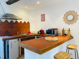 a kitchen with a counter top with a microwave at Appart Karibu in Callian