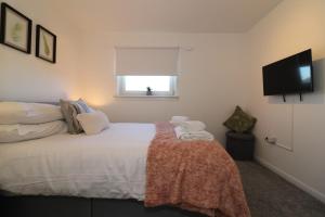 a bedroom with a bed and a flat screen tv at Signature - Honeywell House in Chapelhall